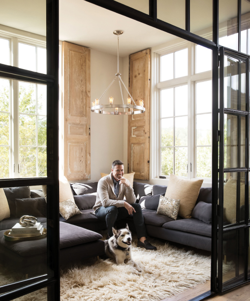 Man with his dog in a house with chandelier